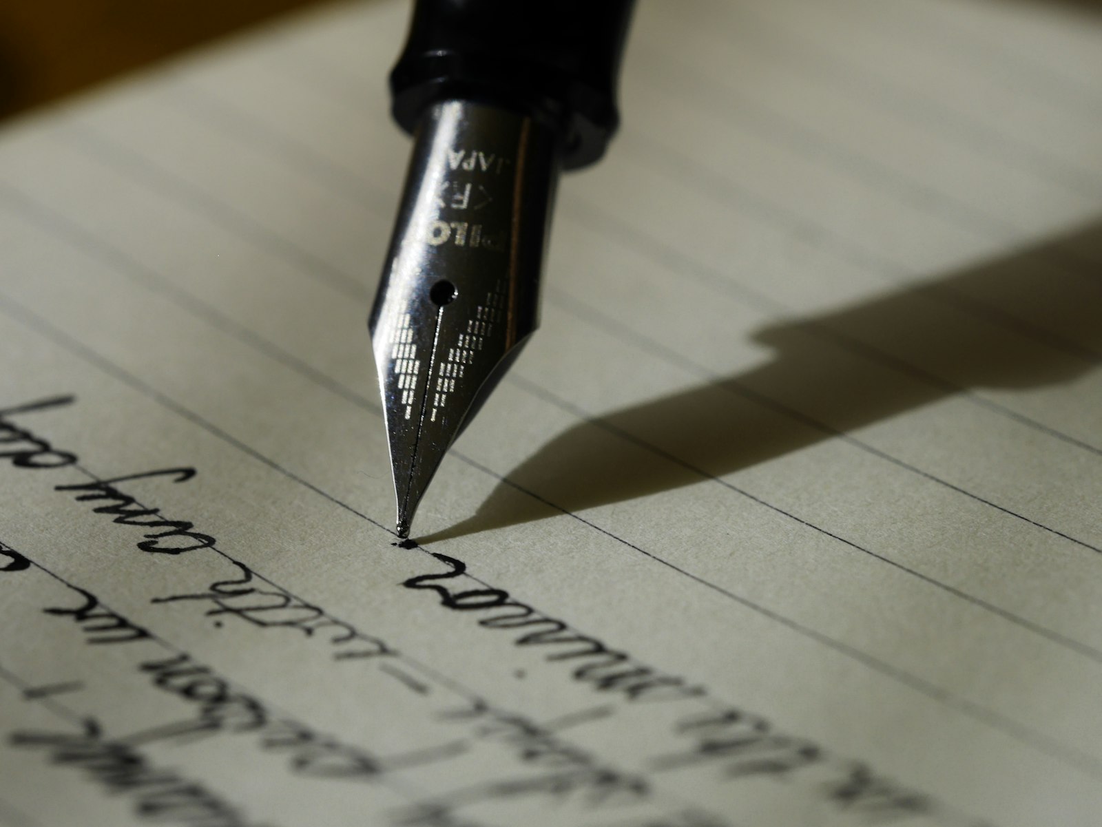 A fountain pen resting on a handwritten page